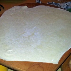 Pizza dough stretched large enough to fill a pizza paddle